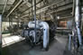 This interior view of the propane compressor building, ca. 2010, shows the two Cooper-Bessemer compressors with the White Superior compressor in the background. <br />Source: Alberta Culture and Tourism