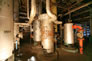 Interior of the 1952 propane plant, showing three caustic knock-out drums, ca. 2010; the plant had a closed system that used a caustic solution to remove unwanted compounds from the propane. In the knock-out drums, the caustic solution was separated from the unwanted material and re-circulated through the system. <br/>Source: Alberta Culture and Tourism