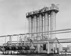 The absorption plant with reabsorber tower at right, February 1945. <br/>Source: Glenbow Archives, IP-6d-4-5