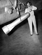 A Gulf Oil Co. employee examines the "bird" of an aerial magnetometer, June 25, 1947, by photographer Eric Bland. The magnetic method evaluates the differences in magnetic character of subsurface rock. Metamorphic and igneous rock can be distinguished from the sedimentary rock where petroleum reserves often lie because they exert a stronger magnetic pull and so distort the data gathered. By 1946, the airborne magnetometer was preferable to the surface magnetometer as it is easier to use over rough terrain where there are pipelines and railroads. Nonetheless, it was largely replaced by seismic methods by the late 1950s. Source: City of Edmonton Archives, EA-600-178B