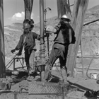 Oil rig near Drumheller, 1962; despite some labour condition improvements since the 1920s, working on the rigs was still a dirty and labour intensive job.
