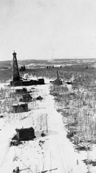 A view of oil well Signal Hill No. 2, taken from the top of oil well Signal Hill No.1, helps to show the height of the monkey board platforms atop the oil derricks. These oil wells in the Bragg Creek / Jumpingpound Creek region date from the 1920s; by the 1970s and 80s the derricks were often even taller.