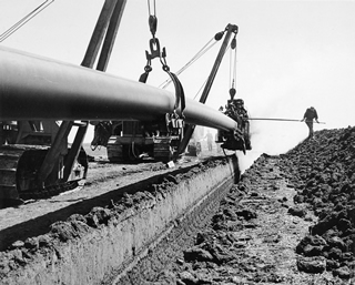 A section of the Interprovincial Pipeline being laid near Regina, Saskatchewan, 1954. Source: Julian Biggs/National Film Board of Canada/Library and Archives Canada/PA-122742