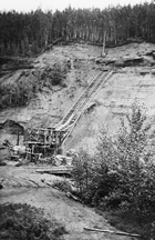 Excavations in tar sands, Athabasca, Alberta, 1933; a cable tramway lowered the mined material to the ground, so it could be taken either to Draper’s plant or directly to the conveniently close railway for shipment elsewhere. <br/>Source: Glenbow Archives, NA-2546-23