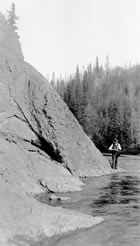 J. A. Allan walks along Turner Valley’s Sheep River with his camera in the summer of 1915. One of his primary duties as a University of Alberta geology professor was to develop a better understanding of the geology of the Turner Valley region. <br />Source: University of Alberta Archives, UAA 77-84-14