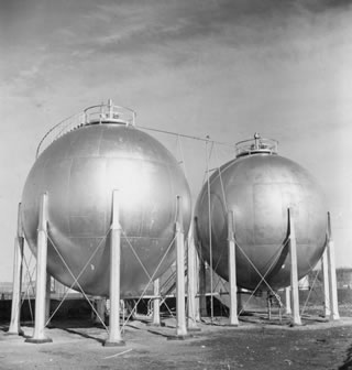 Two Horton Spheres are installed at the Turner Valley plant to store isobutene, a necessary ingredient in the manufacture of high-octane aviation fuel. The spherical shape of these tanks is best for storing high-pressure, volatile petroleum products like isobutene. <br />Source: Glenbow Archives, IP-14a-1472